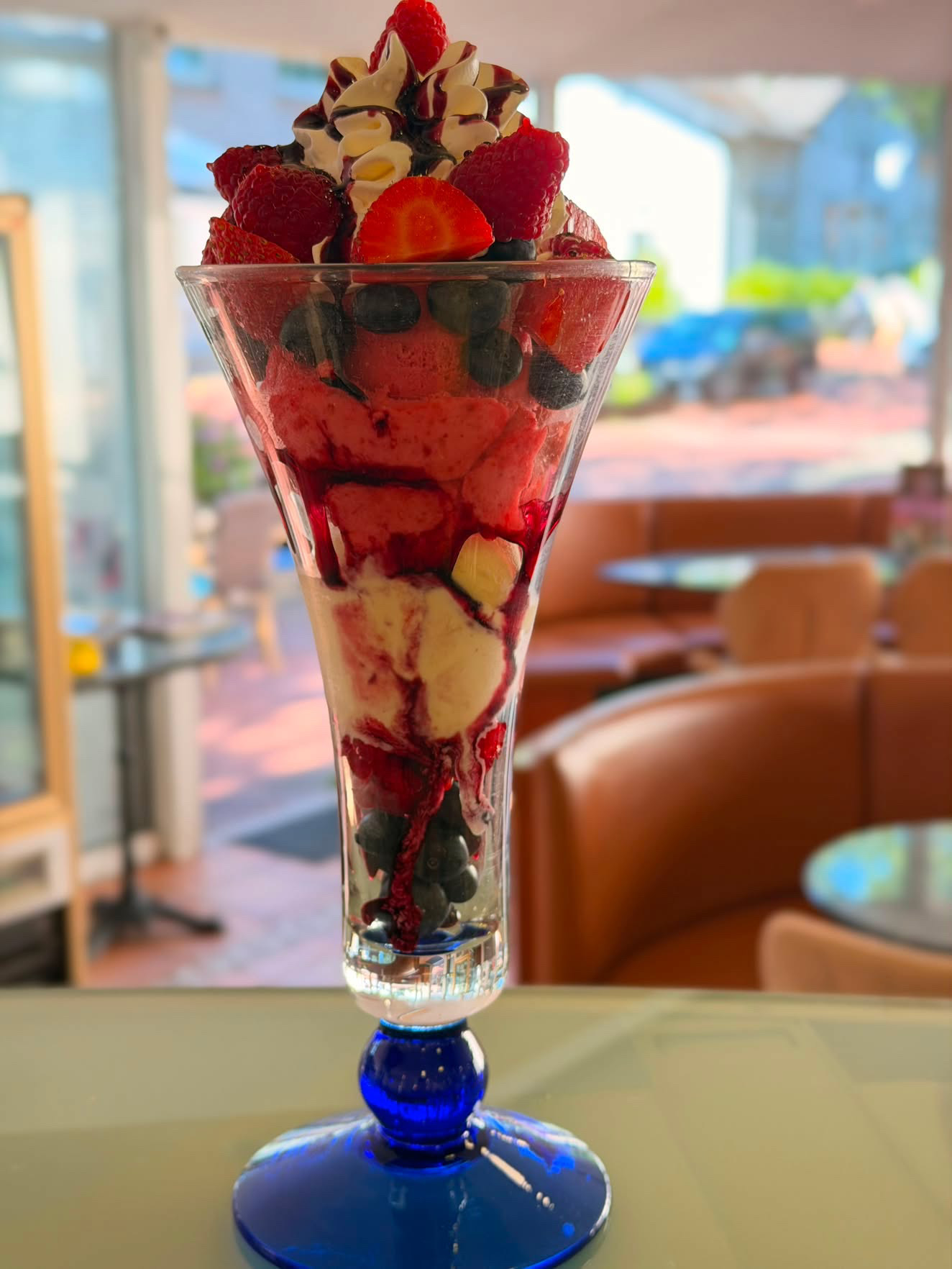 Beeren-Eisbecher mit Erdbeeren, Himbeeren, Blaubeeren und Sahne