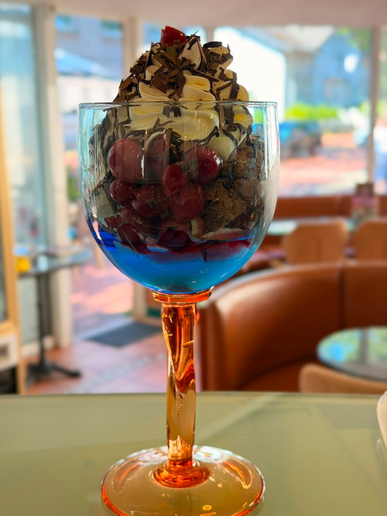 Schwarzwälder-Kirsch-Eisbecher mit Sahne, Schokoraspeln und Kirschen im farbigen Glas