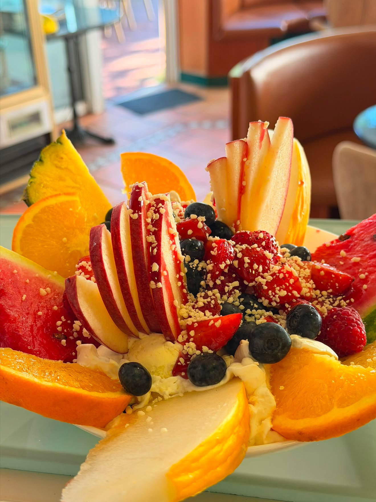 Frischer Früchteteller mit Eis, Apfel, Melone, Orange und Beeren