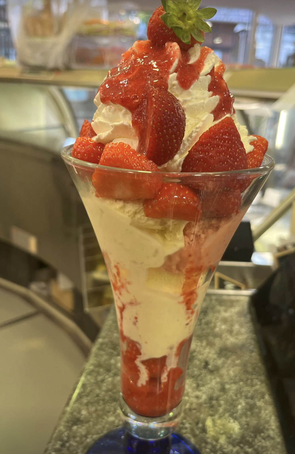 Erdbeerbecher mit frischen Erdbeeren und Sahne im Eiscafé Firenze Munster